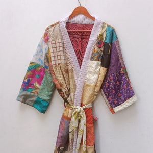 May include: A patchwork robe with a variety of colors and patterns, including purple, pink, blue, and green. The robe has a white sash and is made of silk.