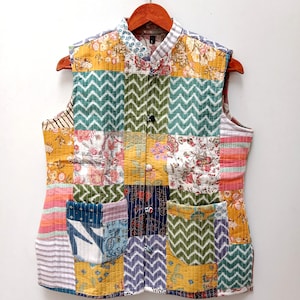 May include: A sleeveless patchwork vest with a mandarin collar and button closure. The vest is made of a variety of colorful fabrics, including floral prints, stripes, and geometric patterns.