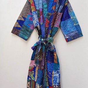 May include: A blue and multi-colored patchwork quilted robe with a tie belt. The robe is made of a soft, comfortable fabric and has a relaxed fit.