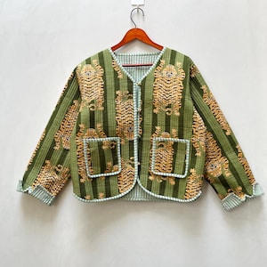 Op de afbeelding: Een groen gewatteerd jack met een tijgerprint en gestreept patroon. Het jack heeft een knoopsluiting en twee zakken.