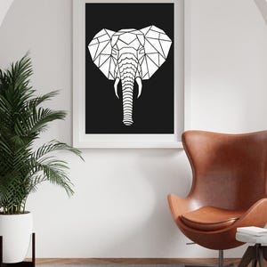 Può includere: Una stampa artistica incorniciata con un design geometrico a testa di elefante in bianco su sfondo nero. L'opera d'arte è in una cornice bianca, ideale per l'arredamento della casa. L'immagine è in un moderno spazio abitativo.