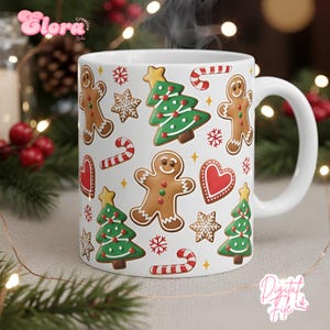 Puede incluir: Taza de cerámica blanca decorada con hombres de jengibre, árboles de Navidad, copos de nieve, bastones de caramelo y corazones. La taza tiene un asa blanca y está llena de una bebida caliente, con vapor saliendo de la parte superior. La taza tiene el texto "Digital File".