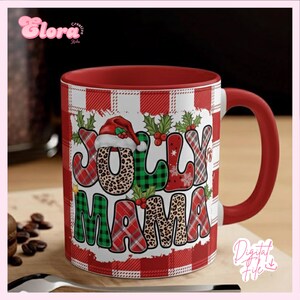 May include: A red and white plaid ceramic mug with a red handle. The mug features the words "JOLLY MAMA" in a mix of patterns, including leopard print, plaid, and a Santa hat. Holly and berries decorate the design.