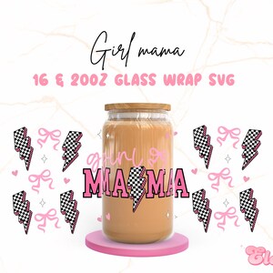 Op de afbeelding: Een glazen pot met een bruine vloeistof erin. De pot heeft een roze en zwart geruit ontwerp met de tekst "Girl Mama" erop. De pot is omringd door roze bliksemschichten en strikken.
