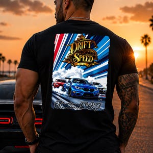 Può includere: T-shirt nero con grafica di auto in drifting, la scritta "DRIFT SPEED" e "Experience The Drift". Il design include un'auto blu, un'auto rossa e un'auto bianca che corrono su una pista. Lo sfondo mostra un tramonto.