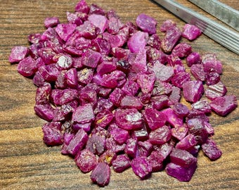 Peut inclure: Un grand tas de pierres précieuses de rubis brutes. Les rubis sont d'une couleur rouge foncé et riche et présentent une variété de formes et de tailles.