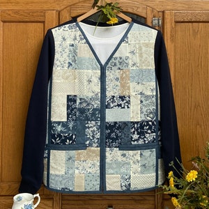 May include: A navy blue jacket with a patchwork waistcoat made of blue and white floral fabric. The waistcoat has a zip fastening and two pockets.