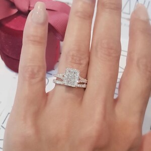 Puede incluir: Un anillo de compromiso de diamante de forma cuadrada con un engaste halo y una banda doble. El anillo est&aacute; engastado en oro blanco y presenta una piedra central grande rodeada de diamantes m&aacute;s peque&ntilde;os.