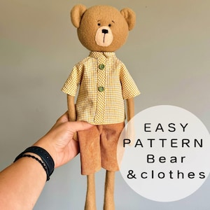 Puede incluir: Una muñeca de oso de peluche hecha a mano con una camisa de cuadros amarillos y pantalones cortos de pana. El oso tiene un cuerpo marrón, una cara marrón claro y está siendo sostenido por una persona. El texto "EASY PATTERN Bear & clothes" está en un círculo blanco.
