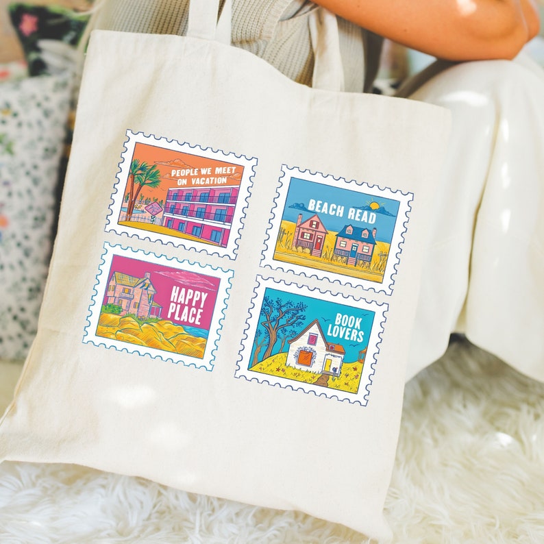 May include: A white canvas tote bag featuring four colourful illustrations of houses. Each illustration is framed with a blue and white border that resembles a postage stamp. The text on the stamps reads "People We Meet On Vacation", "Beach Read", "Happy Place", and "Book Lovers".