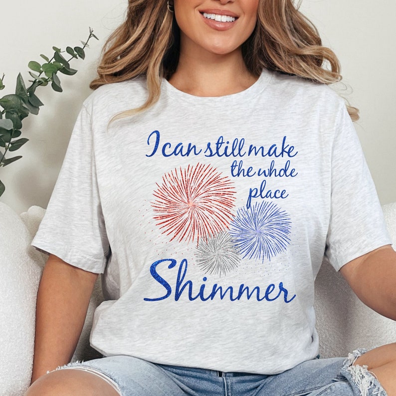 May include: A gray t-shirt with a blue and red firework graphic and the text "I can still make the whole place shimmer".