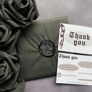 May include: A thank you card with a black and white snake design. The card has the text "Thank you" in a gothic font. The card also includes the text "Don't forget to tag me in pictures on social media and leave a review on Etsy!" and "Thank you for supporting my small business! It really means the world to me!"  The card also includes the text "Spooky blessings, CCD" and the website address "www.cursedcutediabolus.etsy.com".