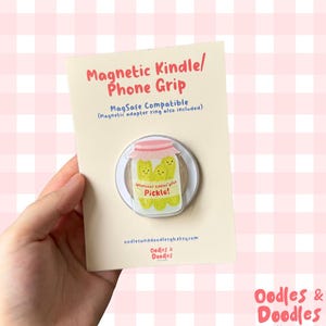 May include: A magnetic phone grip with a cartoon jar of pickles and the phrase "Whatever tickles your Pickle!". It's MagSafe compatible, with a magnetic adapter ring. The card also shows the text "Oodles & Doodles" and the Etsy shop URL.