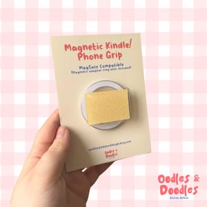 May include: A magnetic phone grip featuring a custard cream biscuit design. The grip is MagSafe compatible and includes a magnetic adapter ring. The product is on a cream card with the text "Magnetic Kindle/ Phone Grip".