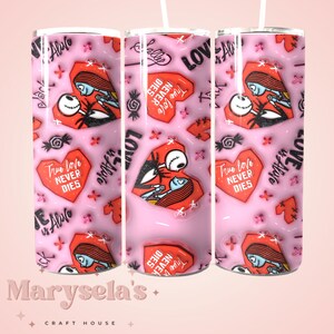 Puede incluir: Un vaso rosa con un patr&oacute;n repetido de gr&aacute;ficos de corazones rojos, ilustraciones de Jack y Sally y el texto "True love NEVER DIES" y "LOVE is Alive". El vaso est&aacute; decorado con varios otros gr&aacute;ficos y textos peque&ntilde;os.