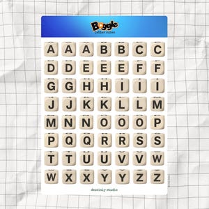 May include: A sheet of Boggle letter cubes with the Boggle logo at the top. Each cube is beige with a black letter printed on it. The letters of the alphabet are displayed in a grid. The words "dessainly studio" are printed at the bottom.
