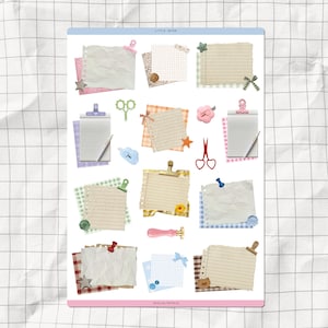 以下が含まれることがあります： スクラップブッキングをテーマにしたステッカーシート。罫線入りの紙、紙の切れ端、装飾クリップ、ハサミ、その他のパステルカラーの装飾が含まれています。シートにはピンクと青のボーダーがあり、「LITTLE NOTES」というテキストがあります。