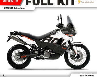 May include: A full kit of motorcycle graphics for a KTM 990 Adventure. The graphics are black, white, and orange with a geometric design. The graphics are available in a white color scheme. The graphics are available on any bike. Contact the seller for more information.