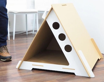 May include: A white and beige wooden dog house shaped like a triangular tent with three round holes on the front.