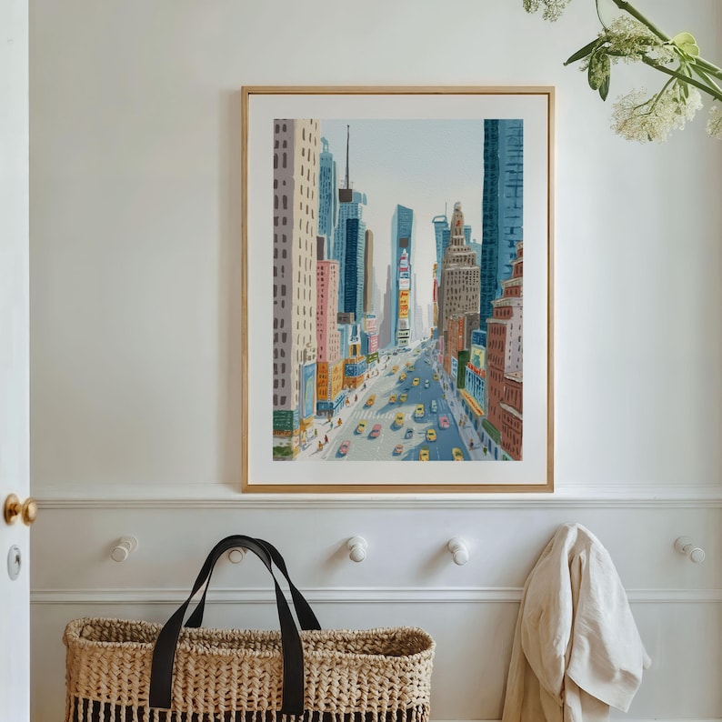 K&ouml;nnte beinhalten: Ein gerahmter Kunstdruck zeigt eine lebendige Stadtlandschaft mit hohen Geb&auml;uden und gelben Taxis auf der Stra&szlig;e. Das Kunstwerk zeigt eine perspektivische Ansicht einer Stadtstra&szlig;e unter einem hellblauen Himmel. Der Rahmen ist hellbraun.