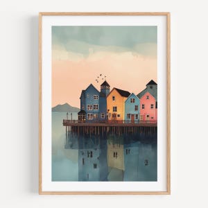 Puede incluir: Impresión en acuarela de edificios coloridos en un muelle, reflejados en el agua. Los edificios están pintados en tonos de azul, naranja, amarillo y rosa, sobre un cielo suave melocotón y azul. Enmarcado en madera.