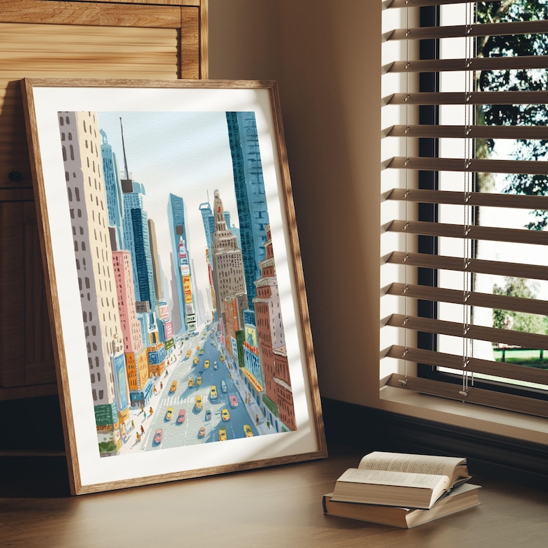 K&ouml;nnte beinhalten: Aquarellmalerei einer Stadtstra&szlig;enszene mit hohen Geb&auml;uden und gelben Taxis. Das Kunstwerk ist in einem hellbraunen Holzrahmen gerahmt und lehnt an einer Wand. Das Gem&auml;lde zeigt eine gesch&auml;ftige st&auml;dtische Umgebung mit farbenfrohen Geb&auml;uden.
