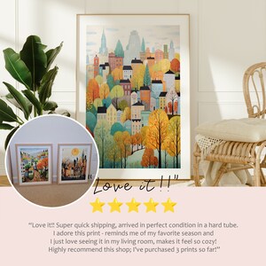 May include: A colorful painting of a city skyline with buildings and trees in autumn colors. The painting is framed and hanging on a wall. The text "Love it!!" is written below the painting.