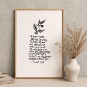 May include: A framed print with two doves and olive branches above handwritten text. The text reads, "When you pass through the waters, I will be with you..." from Isaiah 43:2. The artwork is in a wooden frame.
