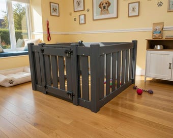 May include: A gray wooden pet gate with vertical slats and a hinged door. The gate is set up on a hardwood floor in a room with dog-themed decor, including framed dog portraits and a dog bed.