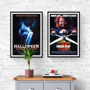 Two movie posters on a white brick wall. The poster on the left is for the movie "Halloween" and features a close-up of Michael Myers' face. The poster on the right is for the movie "Child's Play 2" and features Chucky holding a pair of scissors.