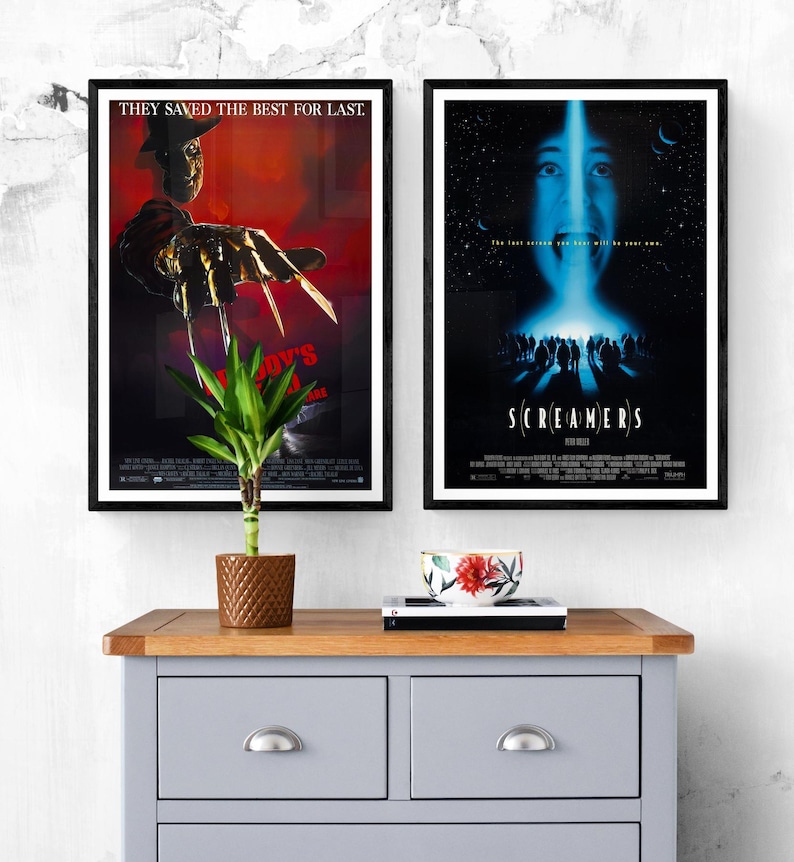 Two movie posters framed in black. The poster on the left features Freddy Krueger from the movie "A Nightmare on Elm Street" with the text "They saved the best for last." The poster on the right features the movie "Screamers" with the text "The last person you hear will be you own."