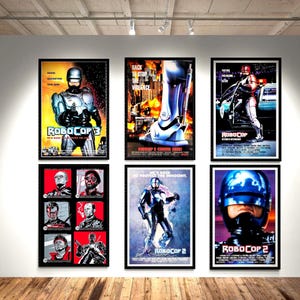May include: Six framed movie posters featuring RoboCop imagery. The collection includes various film titles, character illustrations, and cinematic scenes with metallic blue, red, and black color schemes, displayed in a grid on a white wall.