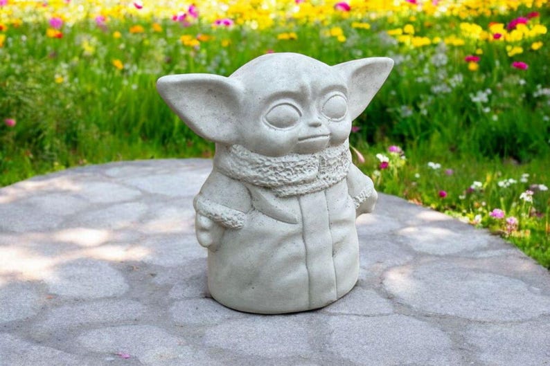 Pu&ograve; includere: Una statua di cemento grigio di un personaggio immaginario con grandi orecchie e un colletto di pelliccia. La statua &egrave; in piedi su un sentiero di pietra grigia.