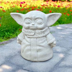 Pu&ograve; includere: Una statua in ceramica bianca di un personaggio immaginario del franchise di Star Wars. Il personaggio indossa un cappotto di pelliccia e ha grandi orecchie.