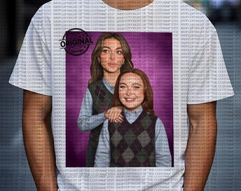 Op de afbeelding: Wit T-shirt met een afbeelding van twee vrouwen, een met bruin haar en de ander met rood haar, die ruitjesvesten dragen over lichtblauwe shirts. De afbeelding bevat de tekst "ORIGINAL Design".