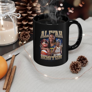May include: Black ceramic mug featuring a basketball player, with the name "ALIVAH" in gold lettering. The mug includes images of the player with a basketball and the text "INDIAN" and "BOSTON". The mug has a black handle and interior.