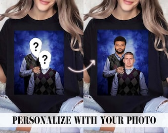 Op de afbeelding: Een zwart T-shirt met een foto van twee mensen met vraagtekens boven hun gezichten. De foto is geplaatst tegen een blauwe en witte wolkachtige achtergrond. De tekst "Personaliseer met je foto" staat onderaan de afbeelding.