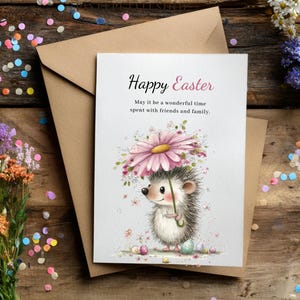 May include: A greeting card with the text "Happy Easter" and a watercolor illustration of a hedgehog holding a flower umbrella. The card is on a brown envelope, with colorful confetti and flowers scattered around.