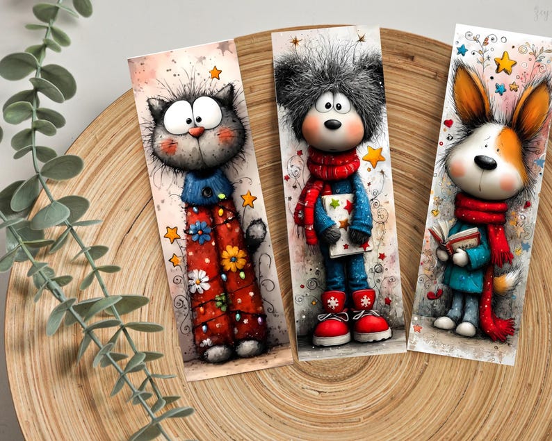 May include: Three illustrated bookmarks with cartoon characters. A grey cat in a blue top and red trousers with flowers. A bear in a red scarf and blue outfit. A dog with a red scarf and a book. Each bookmark is unique.