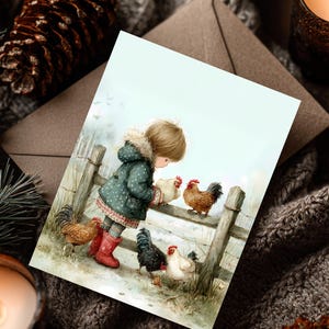 Op de afbeelding: Een wenskaart met een aquarel illustratie van een kind in een groene jas en rode laarzen die interactie heeft met kippen bij een houten hek. De kaart heeft een lichtblauwe achtergrond en is omgeven door een bruine envelop en winterdecoratie.