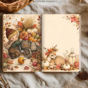 Op de afbeelding: Een open notitieboek met gelinieerde pagina's met herfstthema-illustraties. De linkerpagina toont een kind met een houten kar vol pompoenen en tarwe. De rechterpagina toont een reekalf met een bladerenkroon naast een lantaarn.