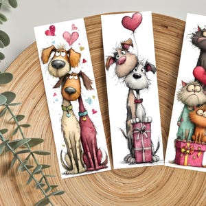 May include: Set of three illustrated bookmarks featuring cartoon dogs and cats. The first bookmark shows two dogs with hearts. The second shows two dogs with a heart balloon and a gift. The third shows three cats with hearts and a gift.