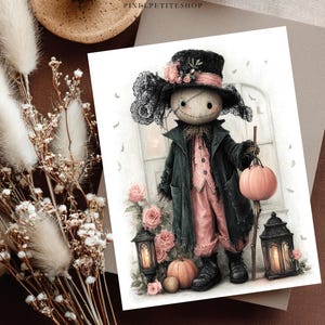 May include: A print featuring a doll with a stitched face wearing a black top hat with pink roses and lace, a dark coat, and pink trousers. The doll holds a pink pumpkin and stands between two black lanterns with candles and pink roses.