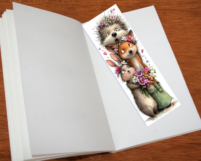 May include: A whimsical bookmark featuring a hedgehog, fox, and rabbit, each adorned with floral crowns. The rabbit holds a bouquet of flowers in a green bag. The bookmark is placed inside an open book.