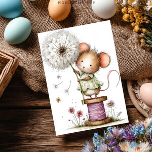 May include: A whimsical illustration of a mouse holding a dandelion. The mouse, with pink ears and a green dress, stands on a spool of thread. Pink flowers and a butterfly are also featured. The artwork is on a white card.