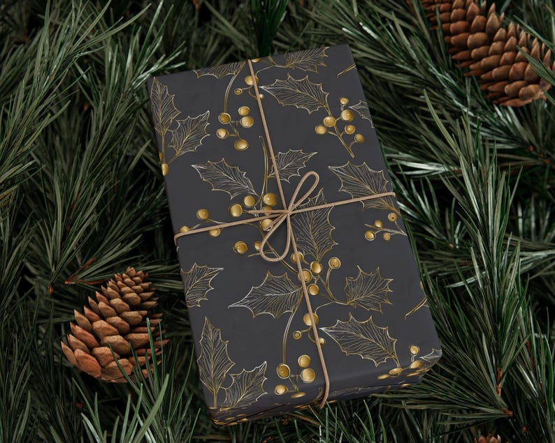 May include: A wrapped gift with a dark gray background and a gold holly and berry pattern. The gift is tied with twine and rests on a bed of green pine needles and pine cones, creating a festive holiday scene.
