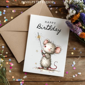 May include: A birthday card with a cute mouse illustration holding a sparkler. The card reads "Happy Birthday" in elegant script. A brown envelope and a bouquet of flowers are next to the card on a wooden surface.