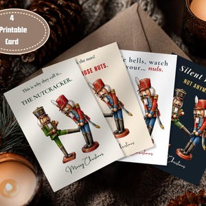 May include: Four printable greeting cards featuring illustrations of nutcracker figures in red and blue uniforms. The cards display humorous text including "This is why they call it... THE NUTCRACKER," "watch your... nuts," and "Silent night? NOT ANYMORE."