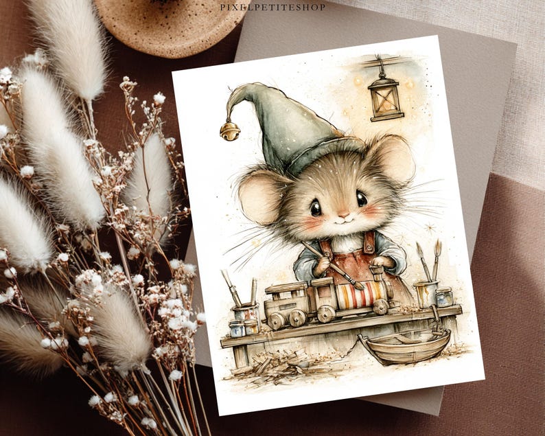 May include: A watercolor-style illustration on a rectangular card featuring a small mouse wearing a green pointed hat with a bell, painting a wooden toy train. The scene includes paintbrushes, jars of paint, and a small wooden boat on a workbench.