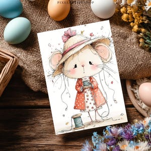 Peut inclure: Illustration &agrave; l'aquarelle d'une souris portant un chapeau de paille et un manteau &agrave; pois rouges, tenant une bobine de fil. L'image est sur une carte blanche, entour&eacute;e d'&oelig;ufs de P&acirc;ques et de fleurs, sur une surface en bois.
